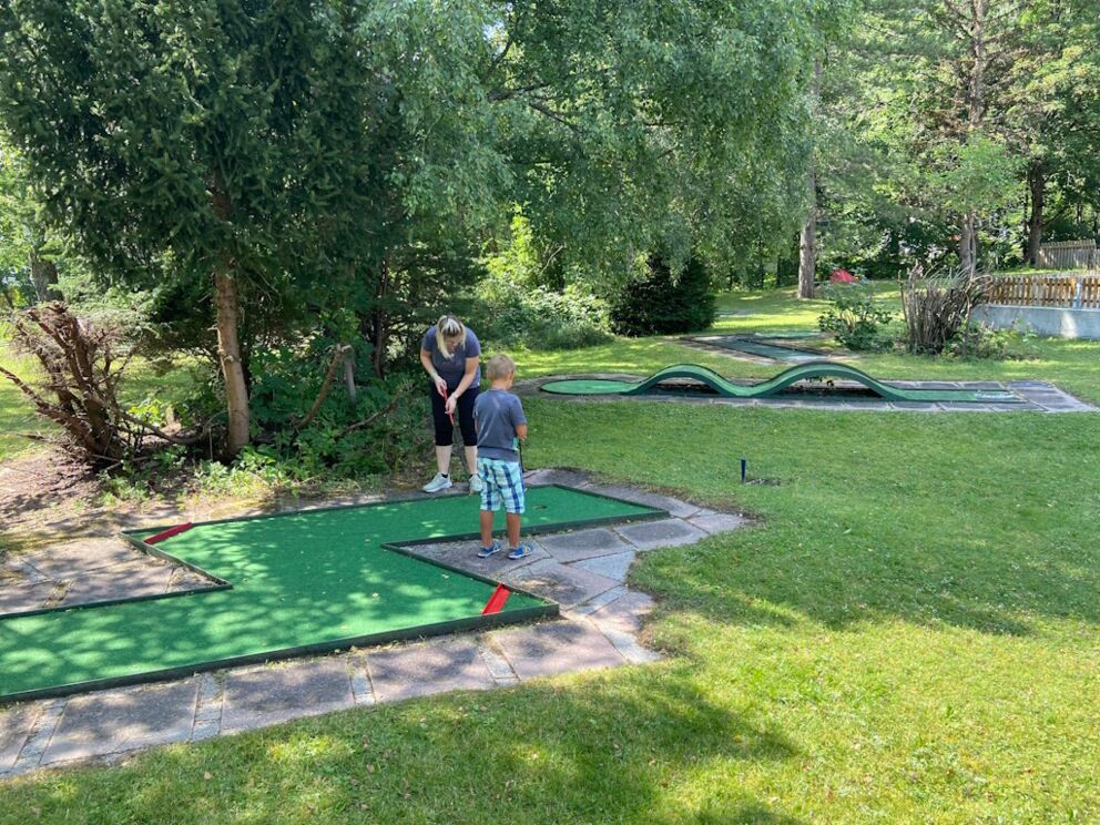 Blitzförmige Minigolfbahn in Holzgau mit zwei Minigolfspieler.