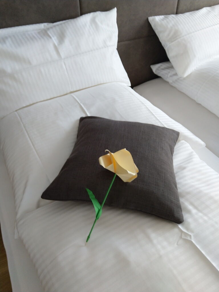 Selbst gefaltete Rose zum Valentin-Tag auf dem Bett in der Übernachtungspension Dorfstube Holzgau