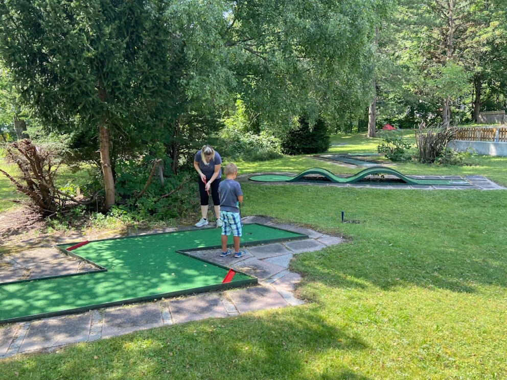 Blitzförmige Minigolfbahn in Holzgau mit zwei Minigolfspieler.