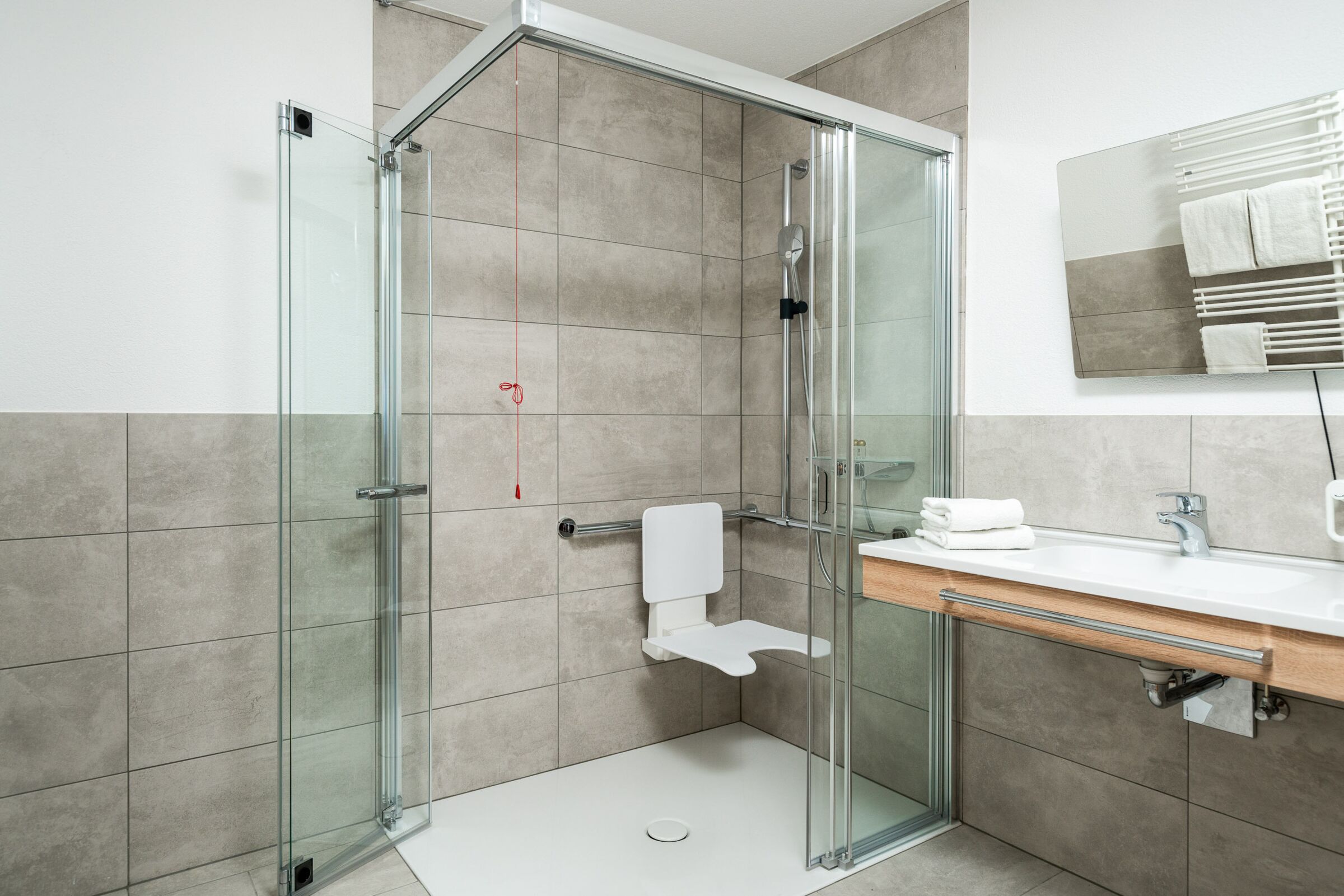 Ein großzügiges Badezimmer mit einer großen Dusche das einen sehr modernen Styl hat.
