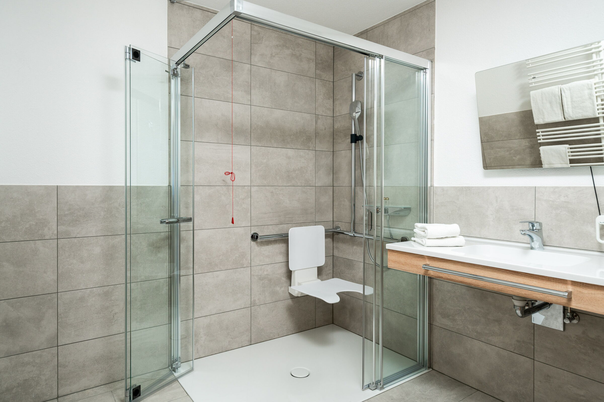 Ein großzügiges Badezimmer mit einer großen Dusche das einen sehr modernen Styl hat.