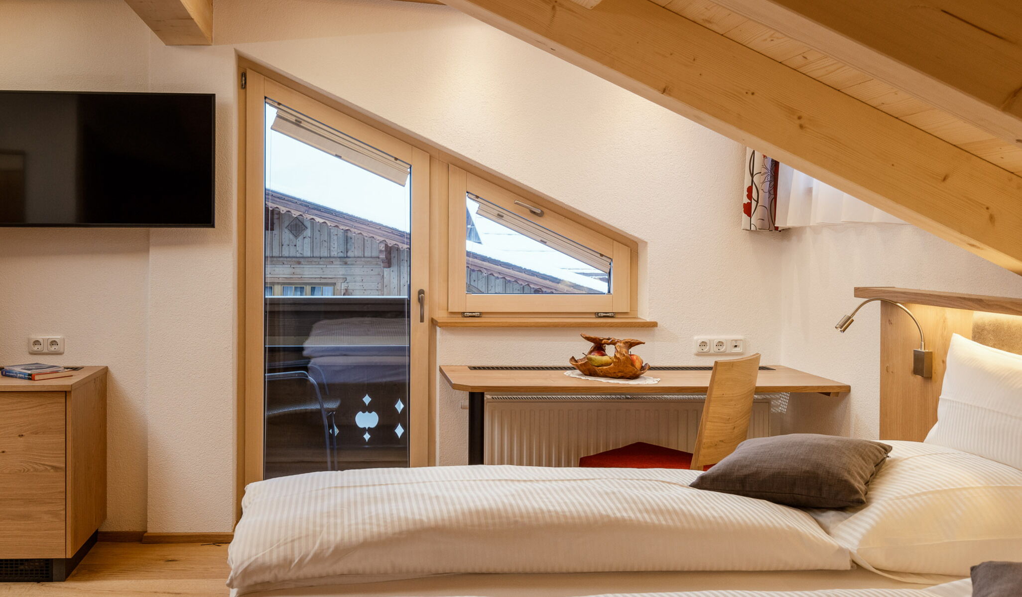 Ein Dachgeschoss Zimmer mit einem Balkon in einem modernen Holz Design