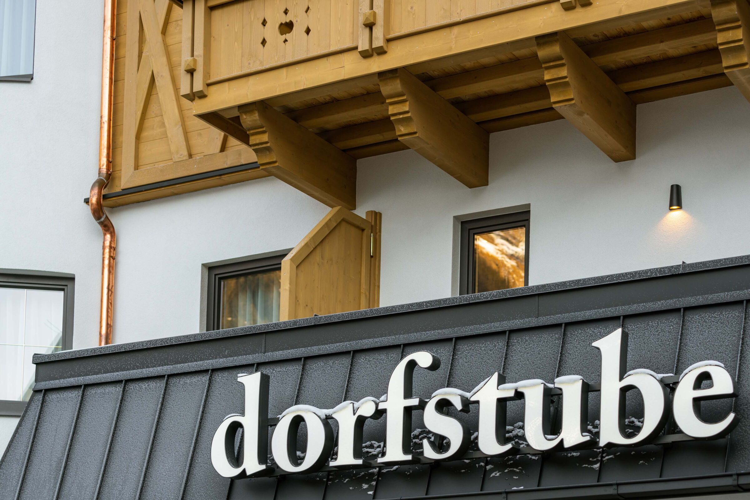 Außenansicht der Dorfstube mit der Aufschrift „Dorfstube“auf dem Gebäude.