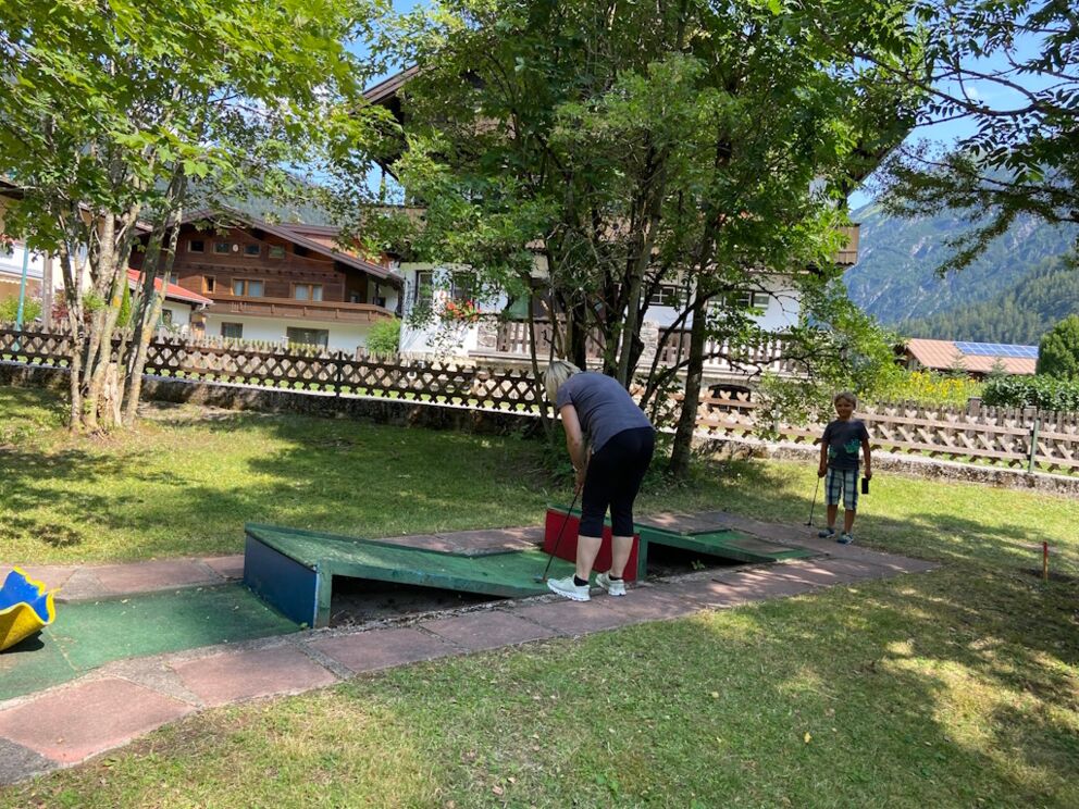 Zwei Minigolfspieler an der schweren Doppelschanzenbahn im Naturpark-Lechtal in Holzgau.