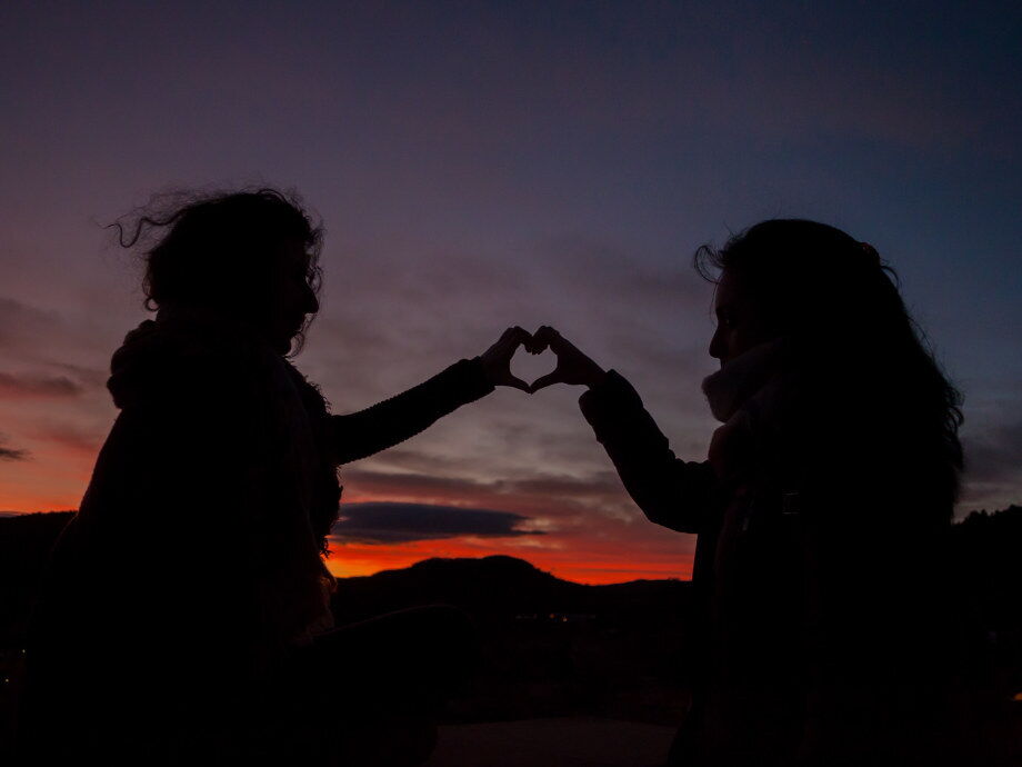 Die Silhouette von einem Paar beim Sonnenuntergang; © MIGUEL GASCOJ auf Unsplash