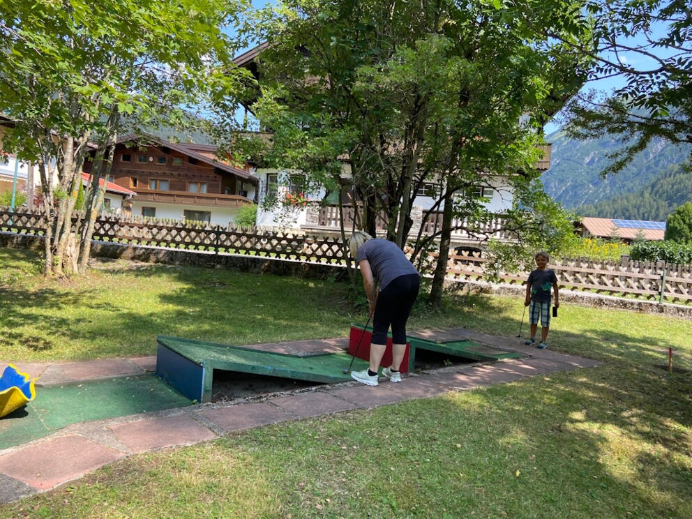 Zwei Minigolfspieler an der schweren Doppelschanzenbahn im Naturpark-Lechtal in Holzgau.