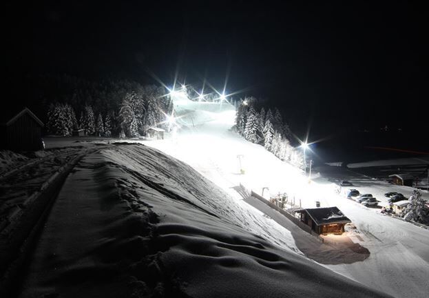 Stanzach-Piste bei Nacht, beleuchtet und schneebedeckt.