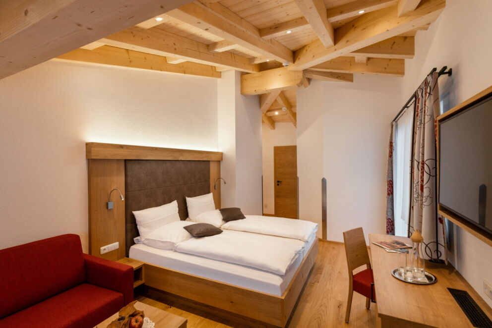 Großes Doppelbettzimmer mit Sichtdachstuhl in der obersten Etage.