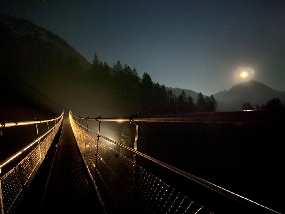 Wandern am späten Abend über die Hängebrücke in Holzgau.