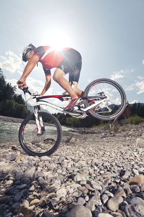 Das Fahrrad fest im Griff und eine gute Balance auf einem Rad am Lechufer im Naturpark-Lechtal.