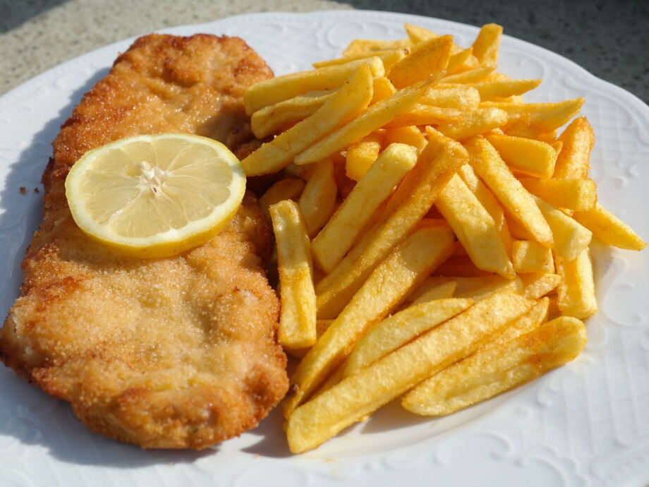 Schnitzel mit Pommes garniert mit einer Zitrone im Restaurant Dorfstube.